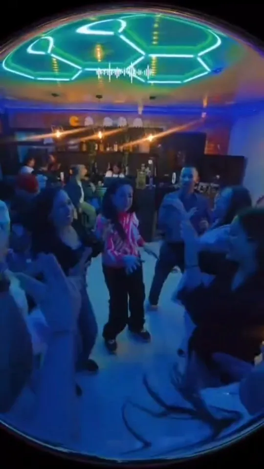 Parche bailando bajo el techo de luces neón hexagonales